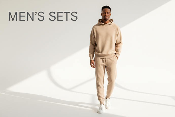 Create a premium banner for the MEN’S SETS collection. Feature a male model wearing coordinated matching sets like jogger sets, co-ords, loungewear sets, or tracksuit sets. Use clean studio lighting with a modern lifestyle vibe. Add elegant typography inside the image that says ‘MEN’S SETS’. Visual style inspired by H&M and BoohooMAN campaigns